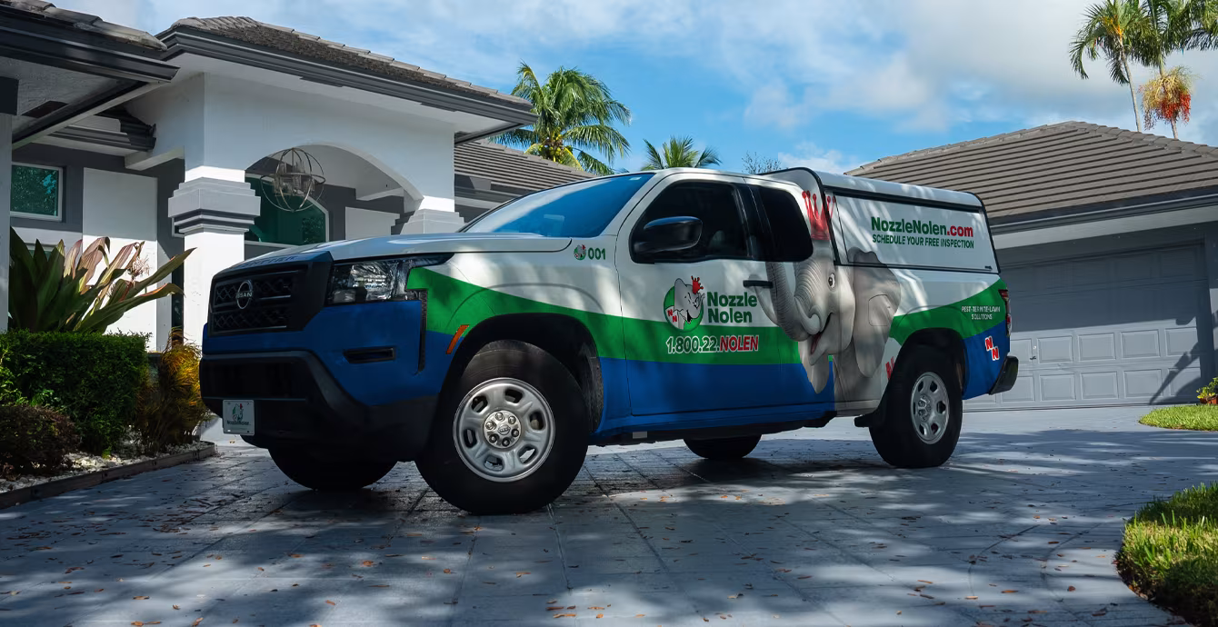 Nozzle Nolen service truck driving through a South Florida neighborhood